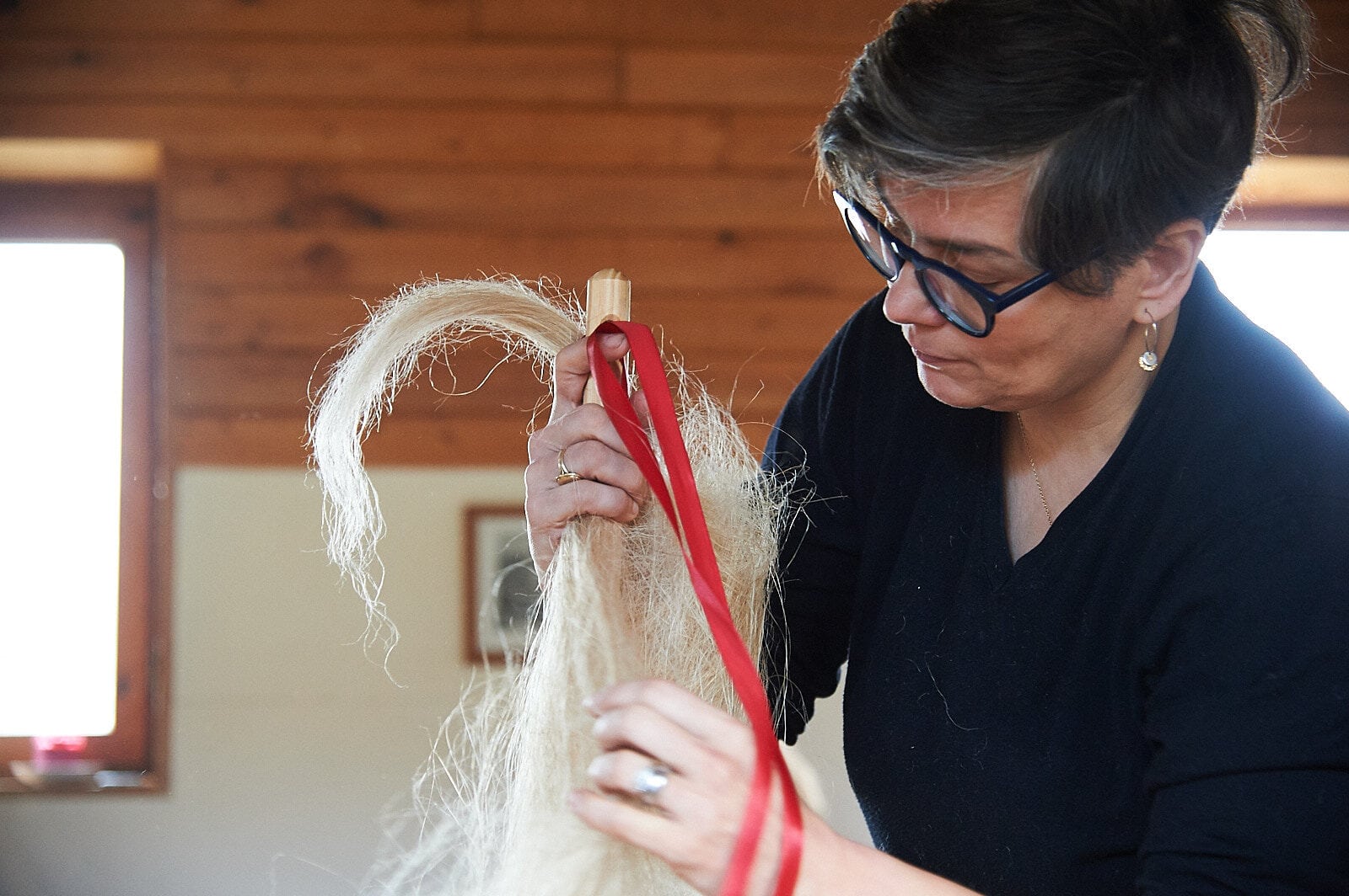 Christiane Seufferlein beim binden eines Flachszopfes auf einen Flachsrocken