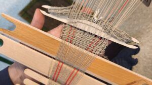 Close-up of a hip loom weaving fabric.
